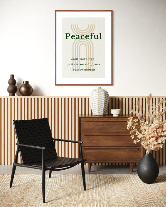 Modern interior with a black chair, wooden dresser, and 'Peaceful' framed artwork.