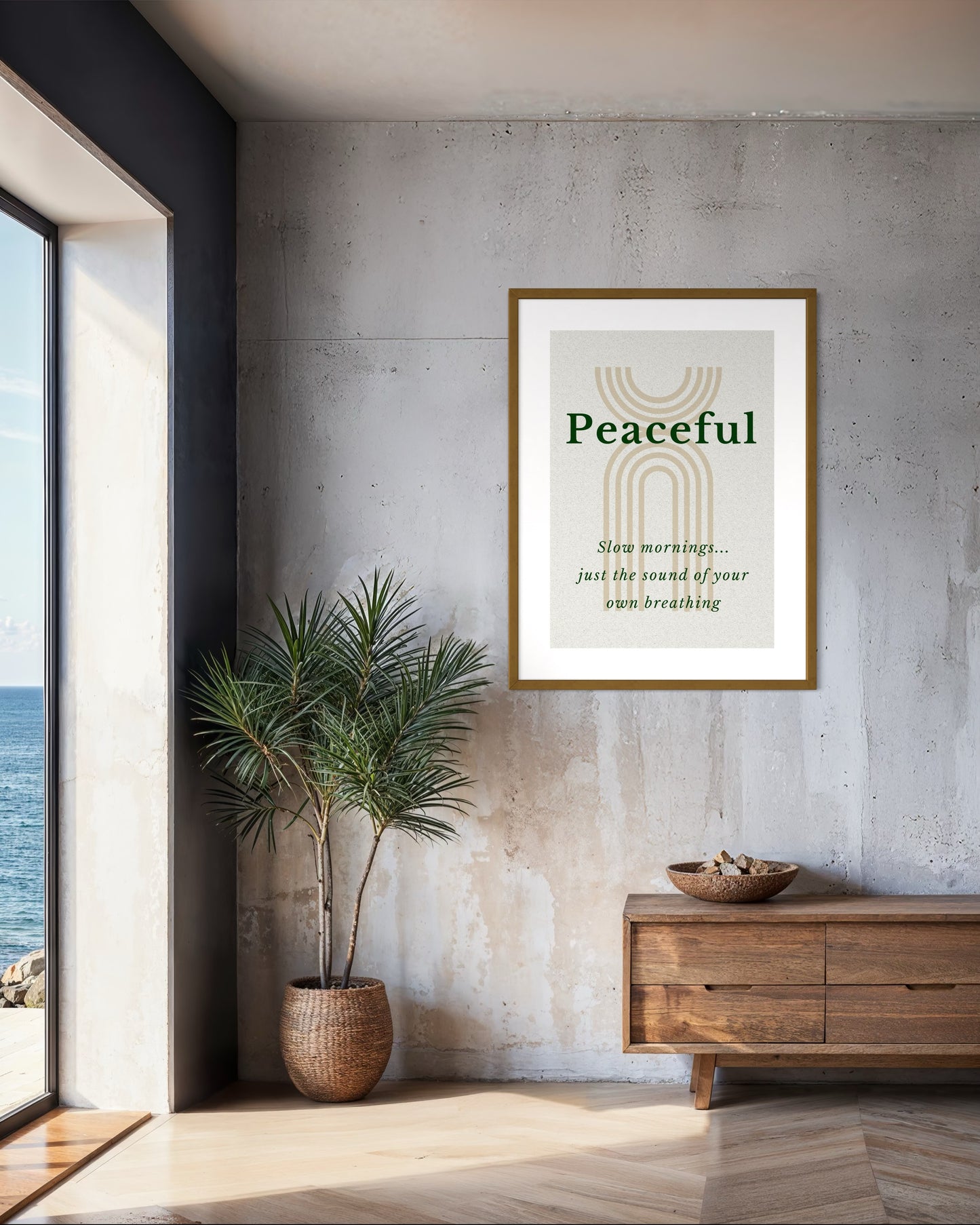 Framed artwork with 'Peaceful' text in a modern interior setting with a plant and wooden cabinet.