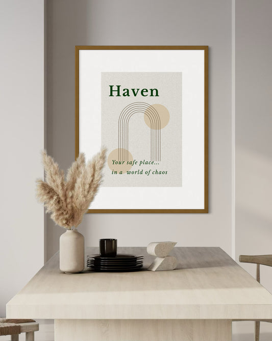 Framed artwork with 'Haven' quote on a wall above a table with decorative items.