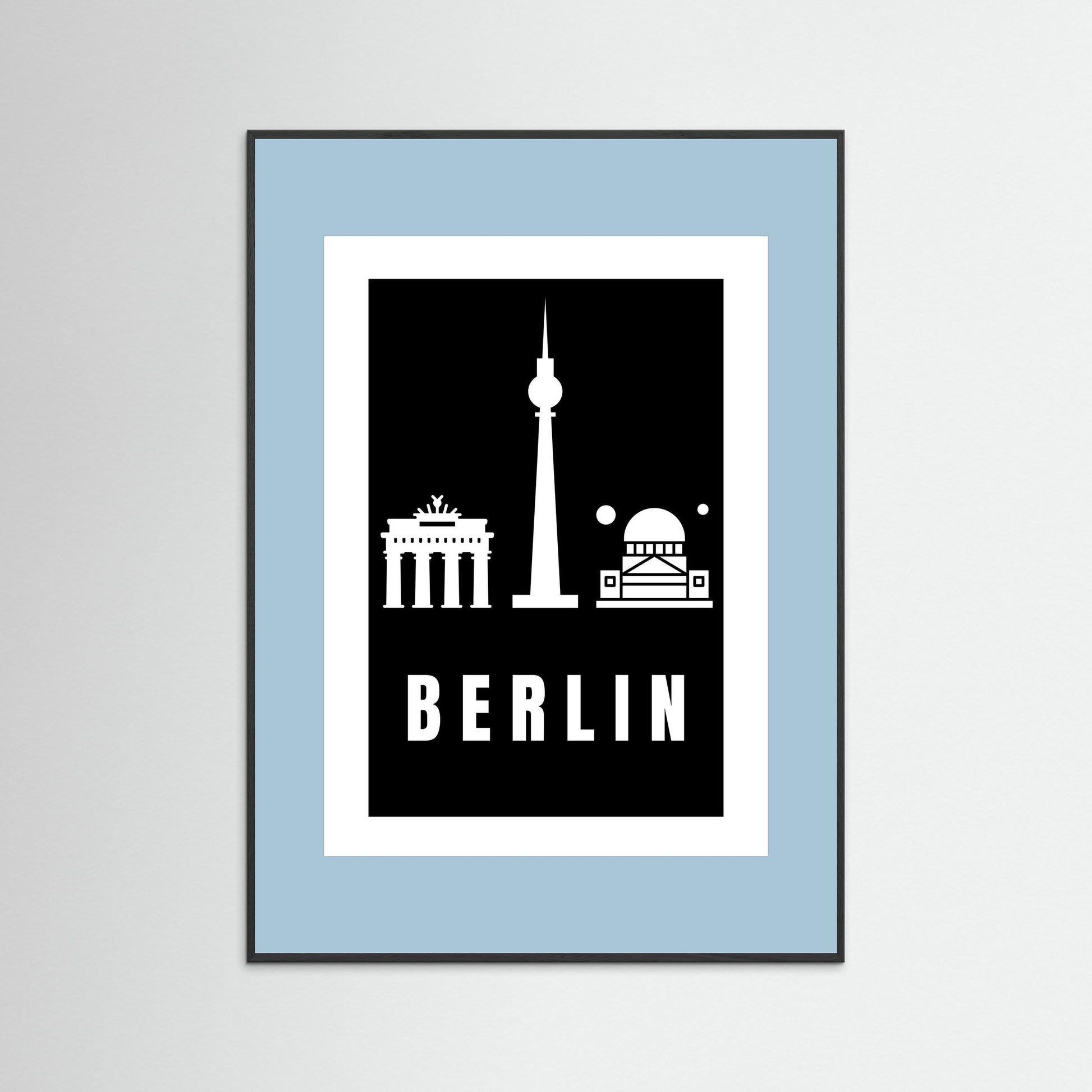 Framed poster with Berlin landmarks on a black background inside a light blue border.