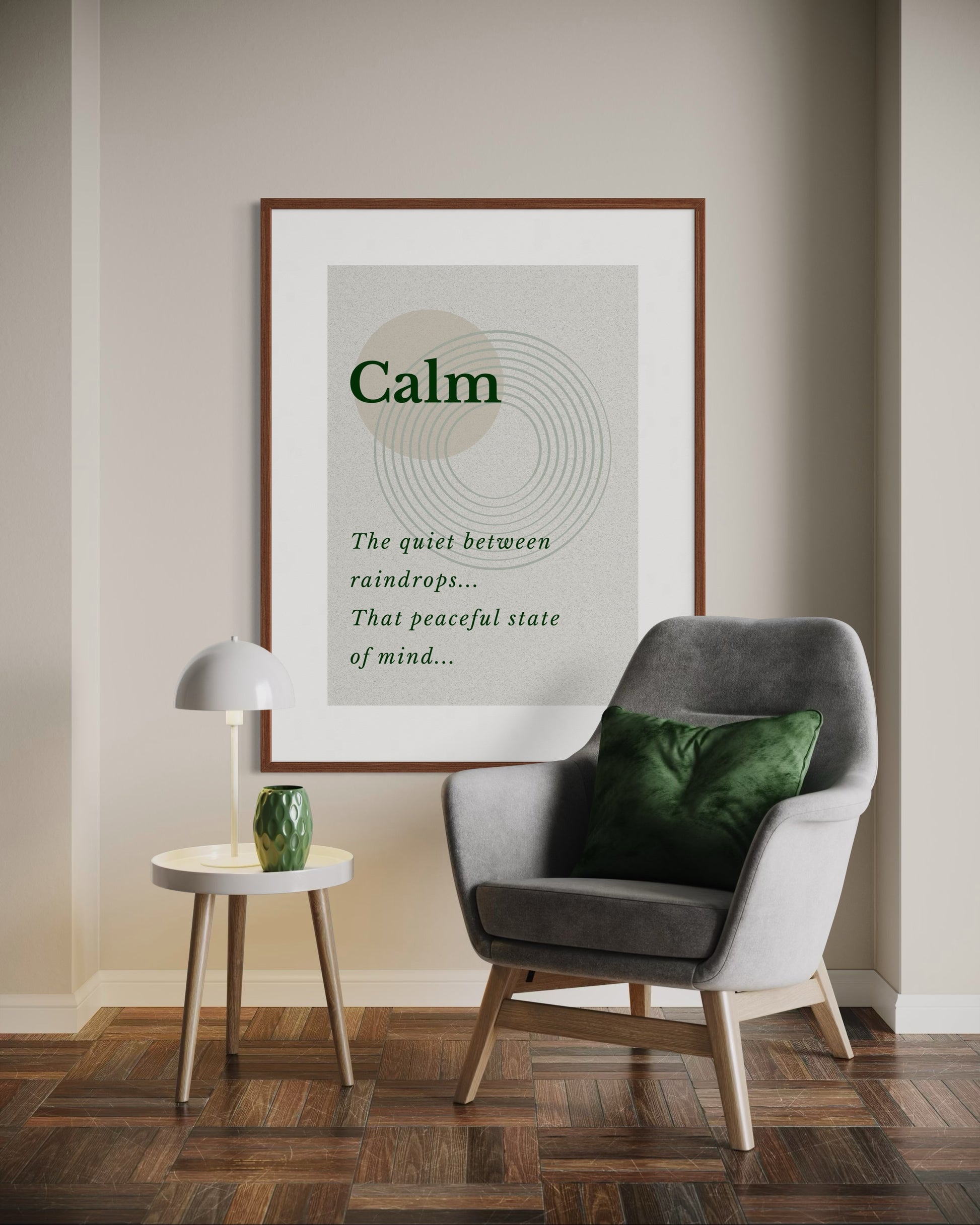 Grey armchair with a green pillow in a room with a framed poster on the wall.