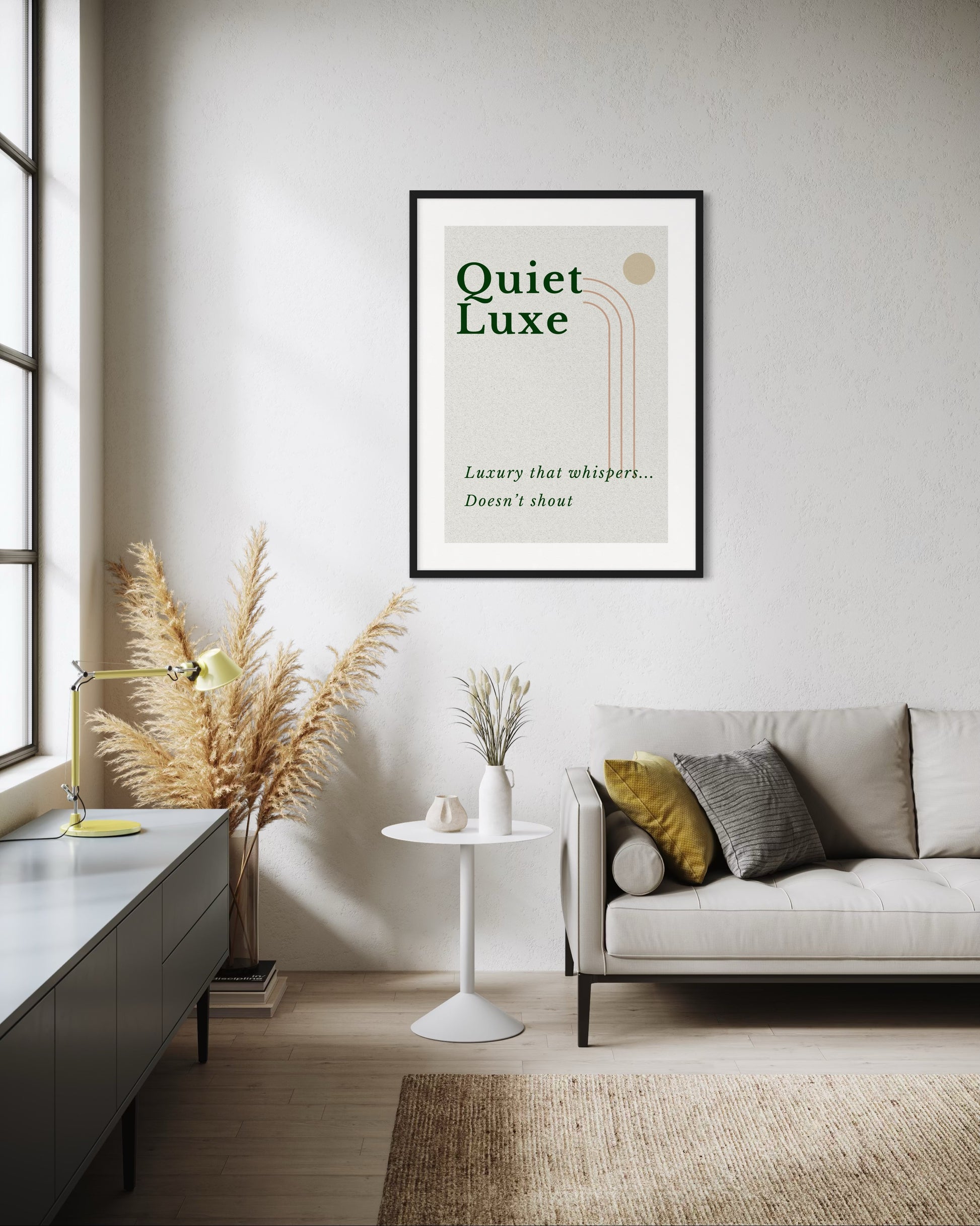 Living room with a framed poster titled 'Quiet Luxe' on the wall, a sofa with pillows, and decorative elements.
