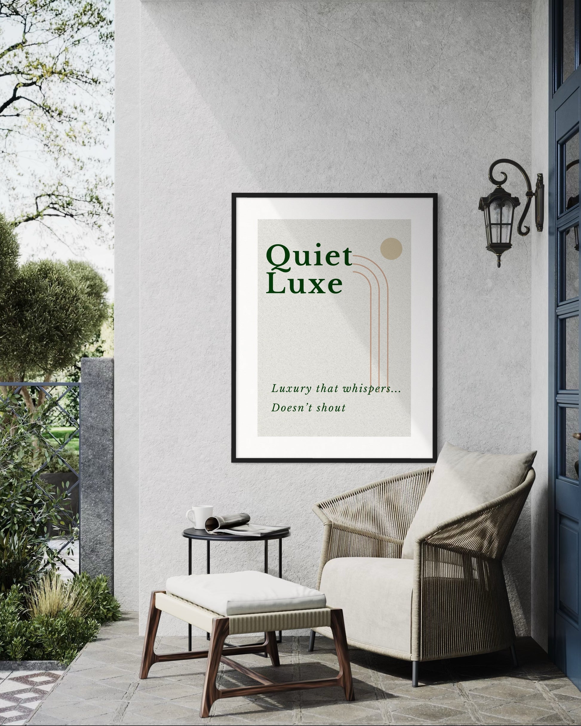 Framed 'Quiet Luxe' poster on a wall with outdoor furniture and garden view.