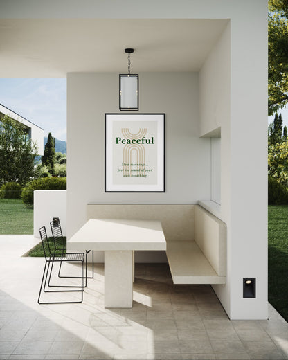 Modern outdoor seating area with a table and chairs, featuring a 'Peaceful' framed print on the wall.