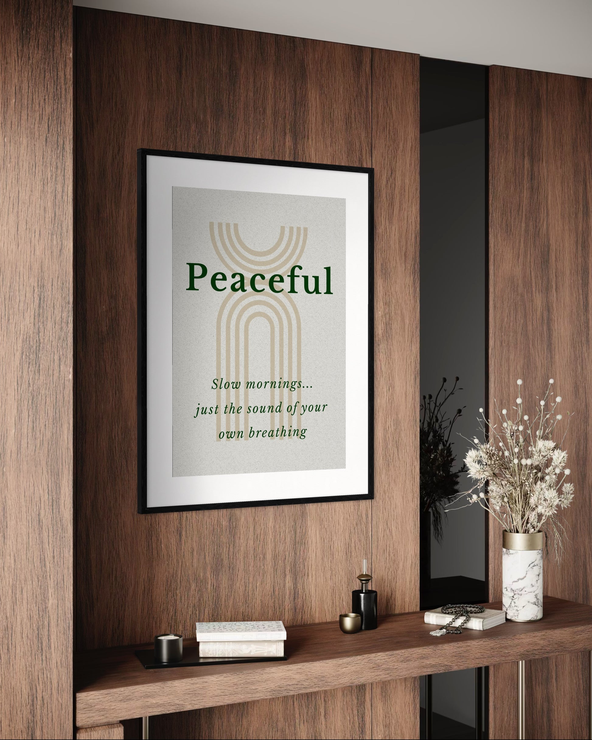 Framed artwork with 'Peaceful' text on a wooden wall with decor items below.