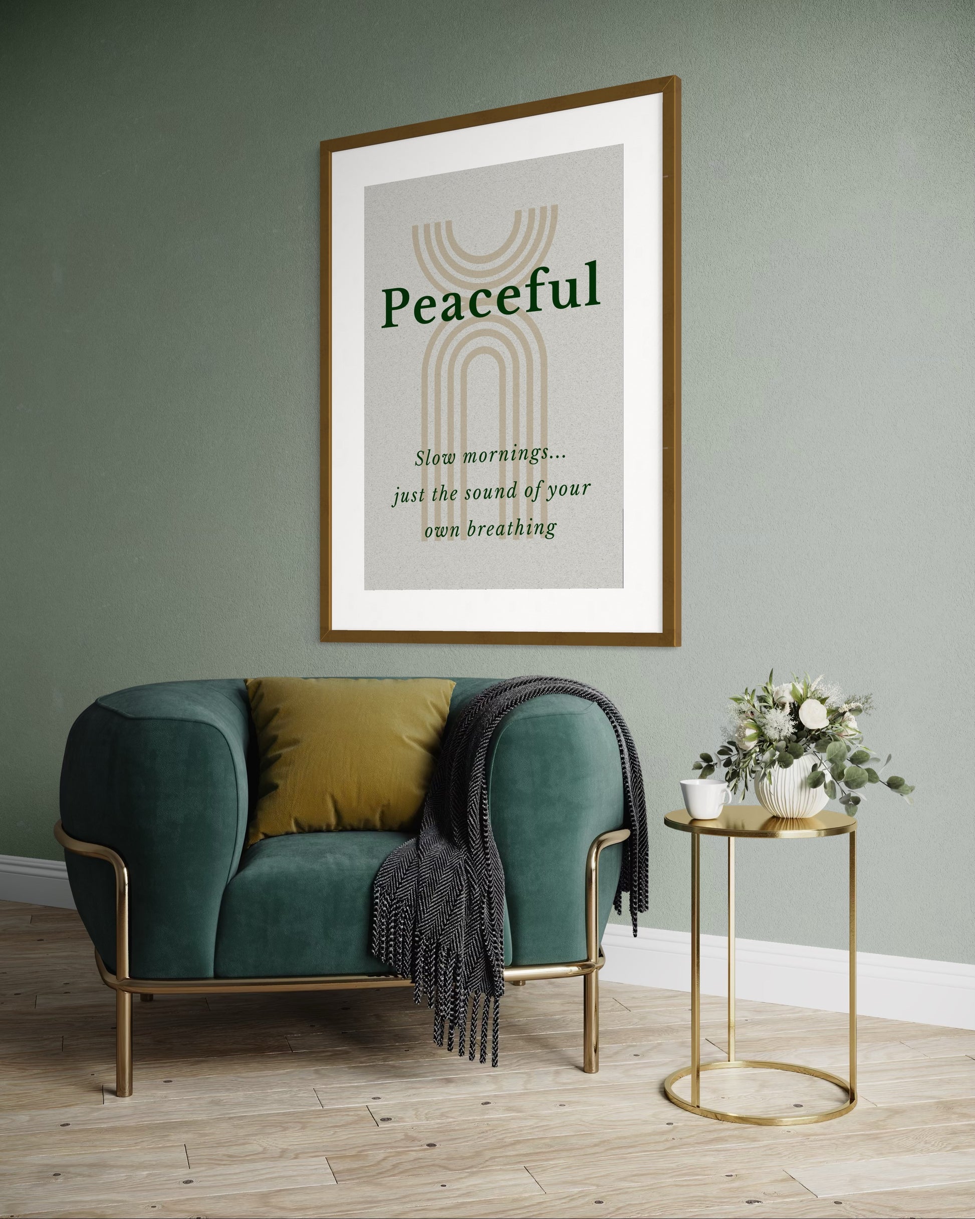 Framed artwork with 'Peaceful' text on a wall above a green armchair in a room.
