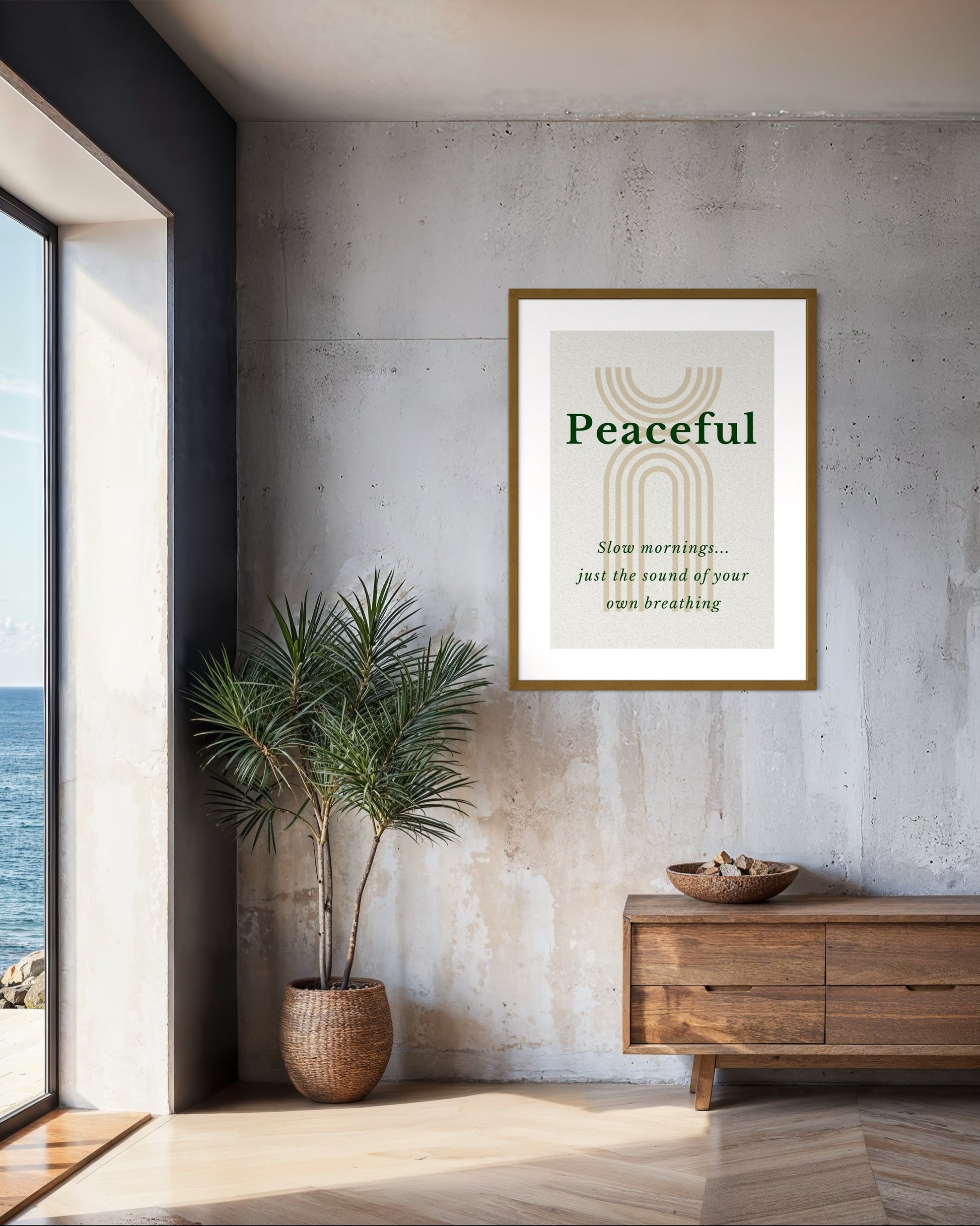 Framed artwork with 'Peaceful' text in a modern interior setting with a plant and wooden cabinet.