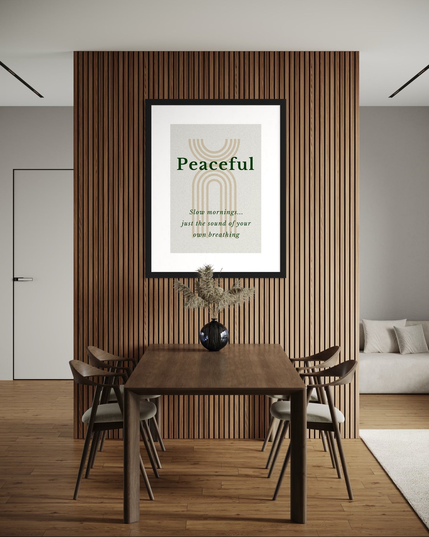 Dining room with a wooden table and chairs, framed artwork on the wall, and a vase with plants.