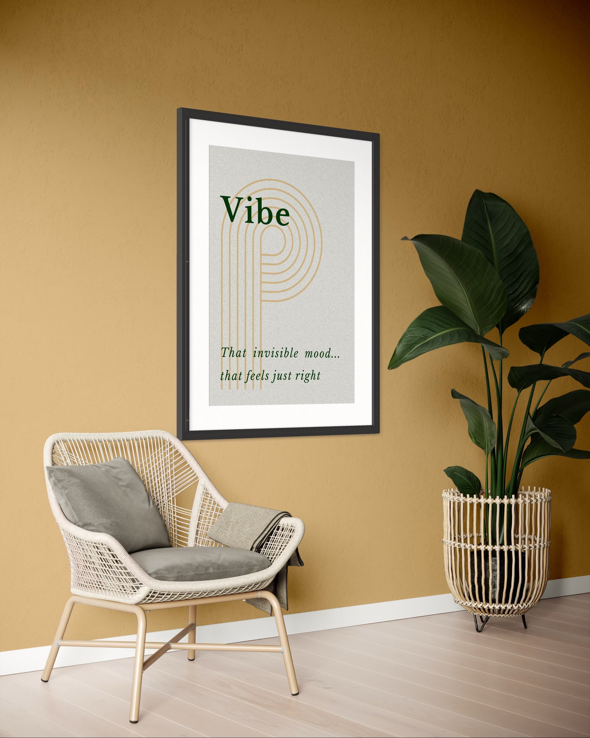 Framed artwork with 'Vibe' text on a wall with a chair and plant in the foreground.