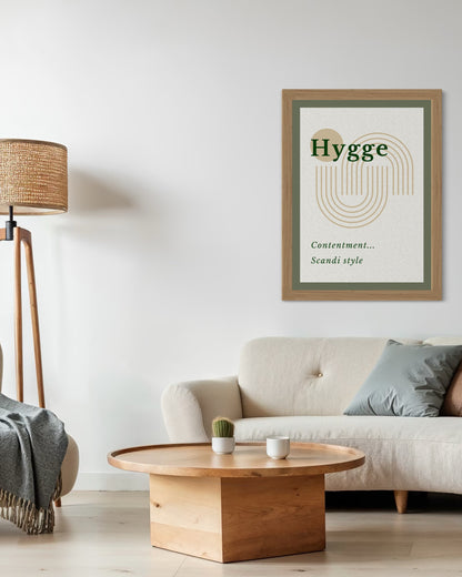 Living room with a 'Hygge' poster on the wall, a beige sofa, wooden coffee table, and lamp.