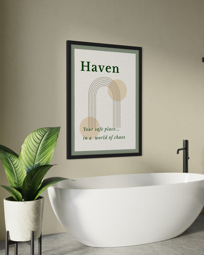 Framed artwork with 'Haven' text above a modern white bathtub and plant.