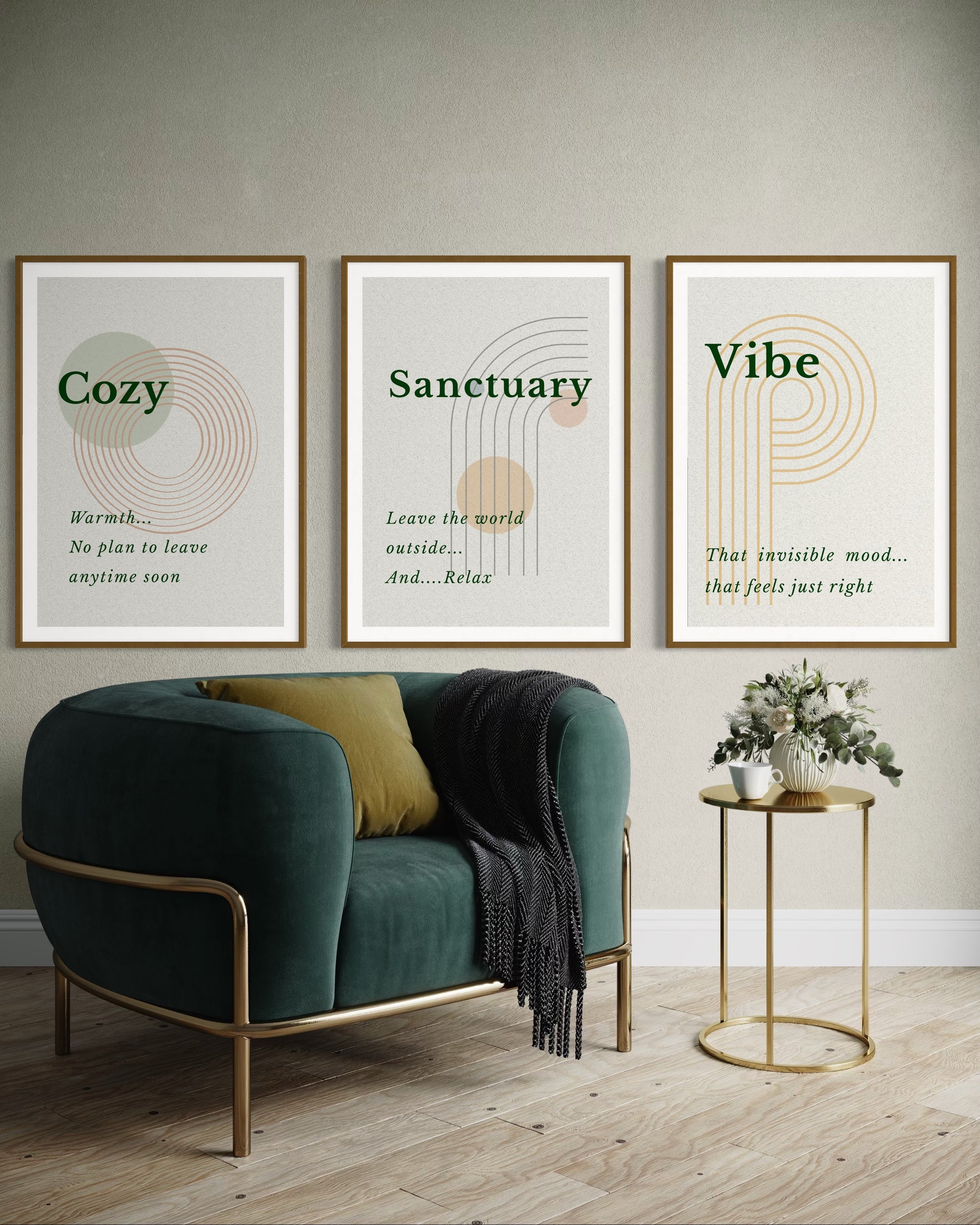 Three framed prints titled 'Cozy', 'Sanctuary', and 'Vibe' above a green armchair with a gold side table.