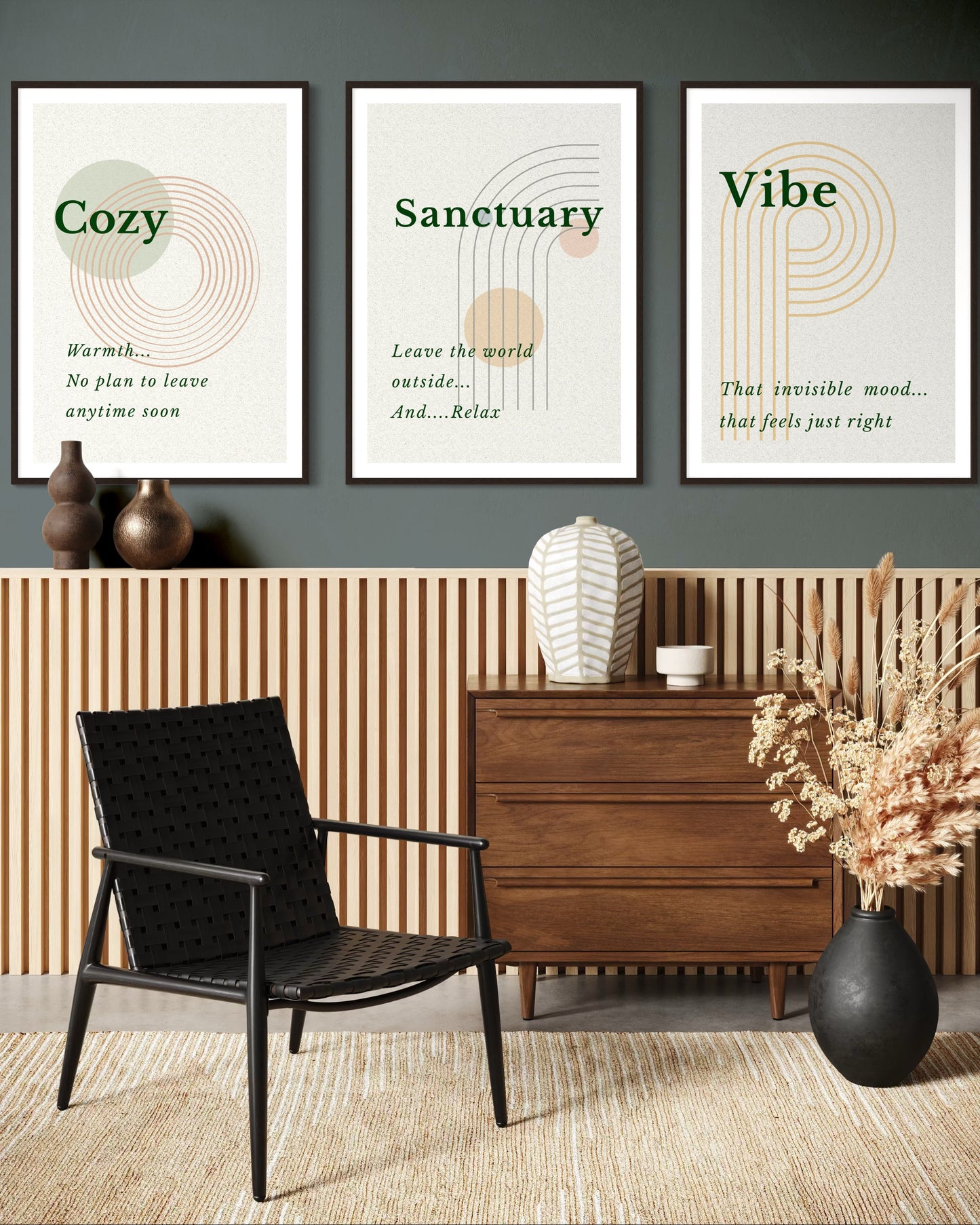 Three framed prints on a wall above a black chair and wooden dresser in a room.