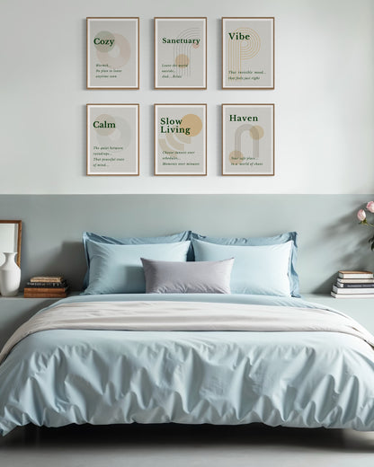 Bedroom with light blue bedding and framed prints on the wall.