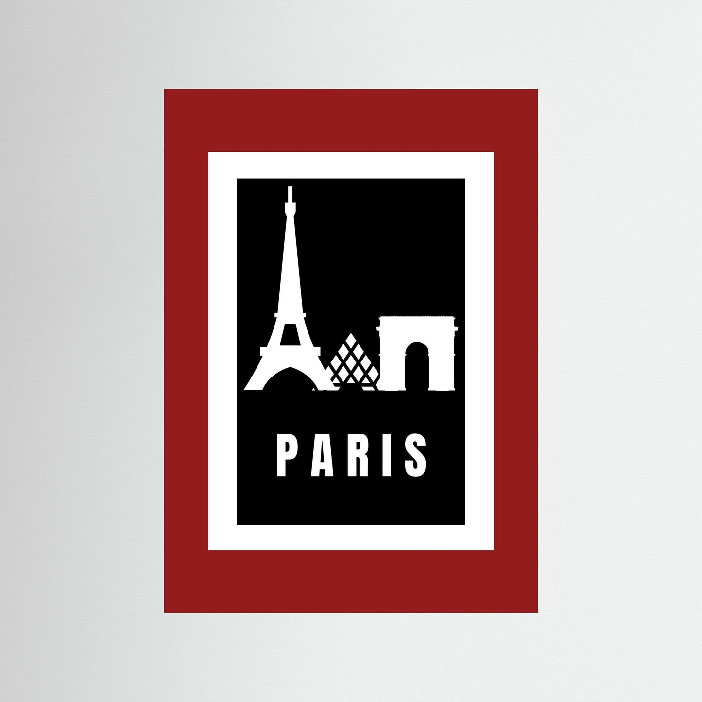 Framed artwork with Eiffel Tower and Arc de Triomphe silhouettes on a black background with 'PARIS' text, framed in red.