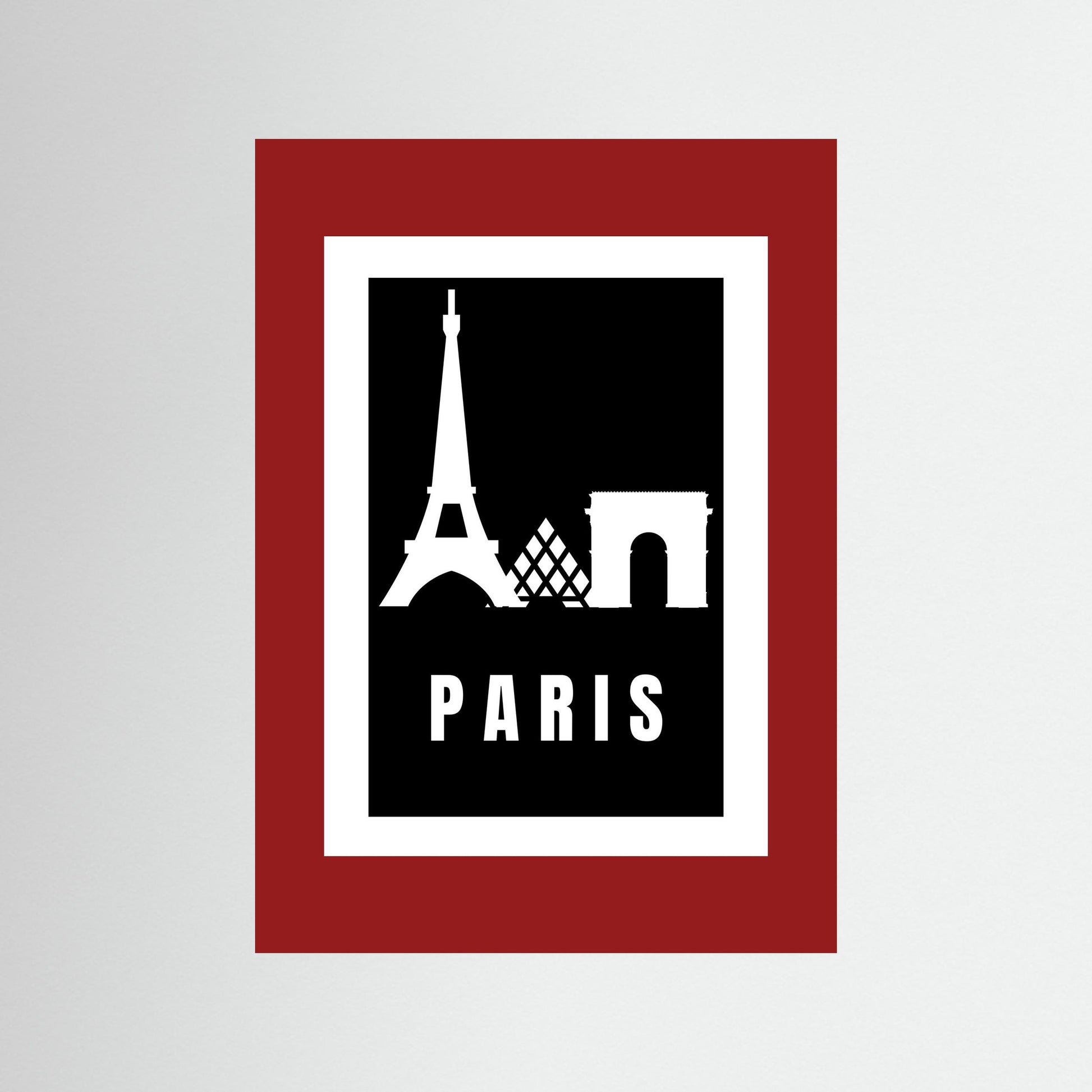 Framed artwork with Eiffel Tower and Arc de Triomphe silhouettes on a black background with 'PARIS' text, framed in red.
