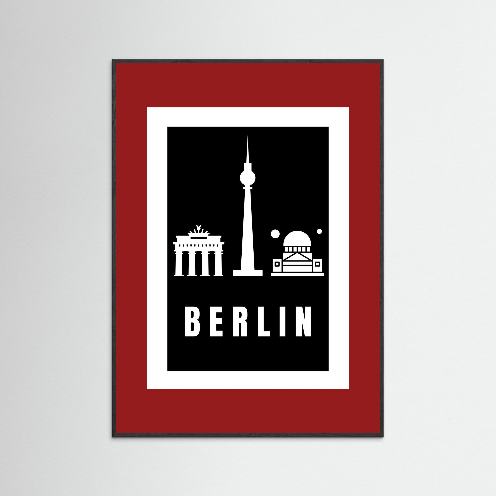 Framed poster with Berlin landmarks on a black background inside a deep red border.