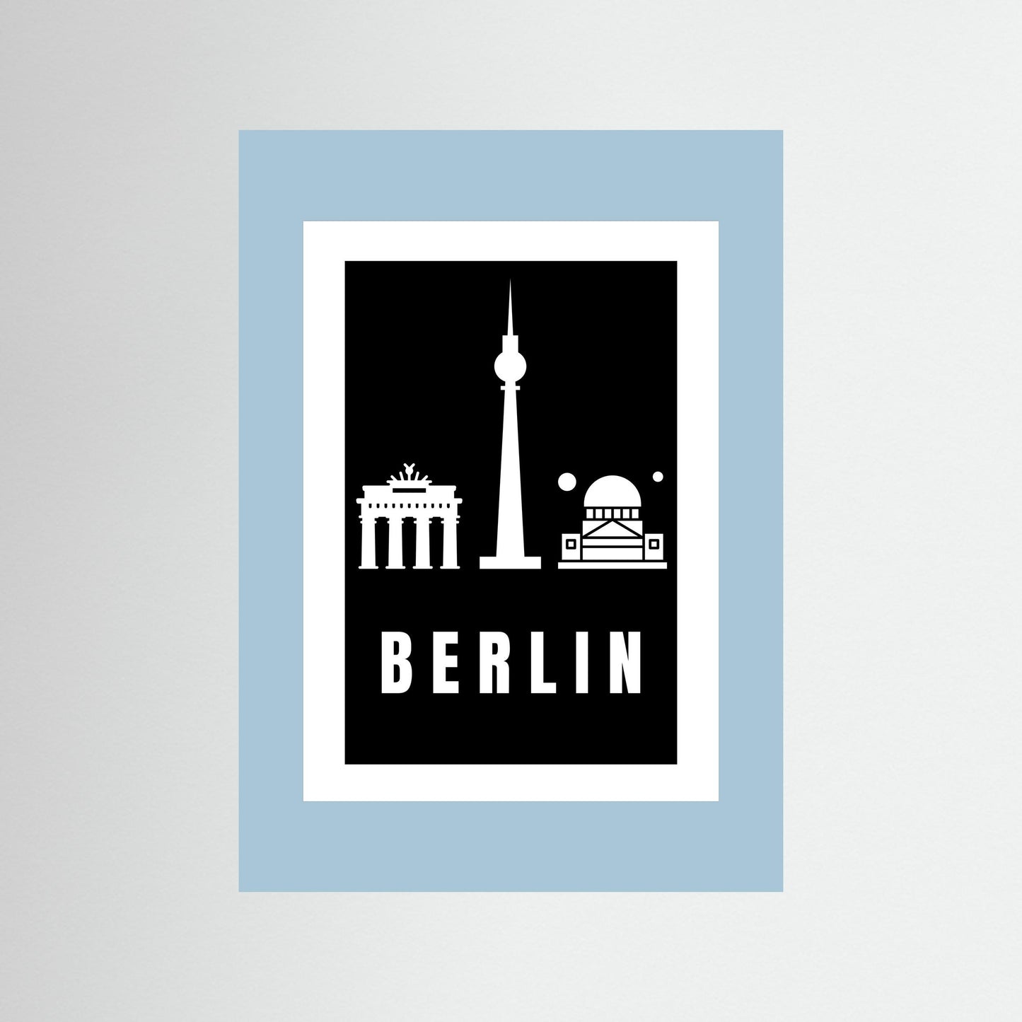 Unframed  poster with Berlin landmarks on a black background inside a light blue border.