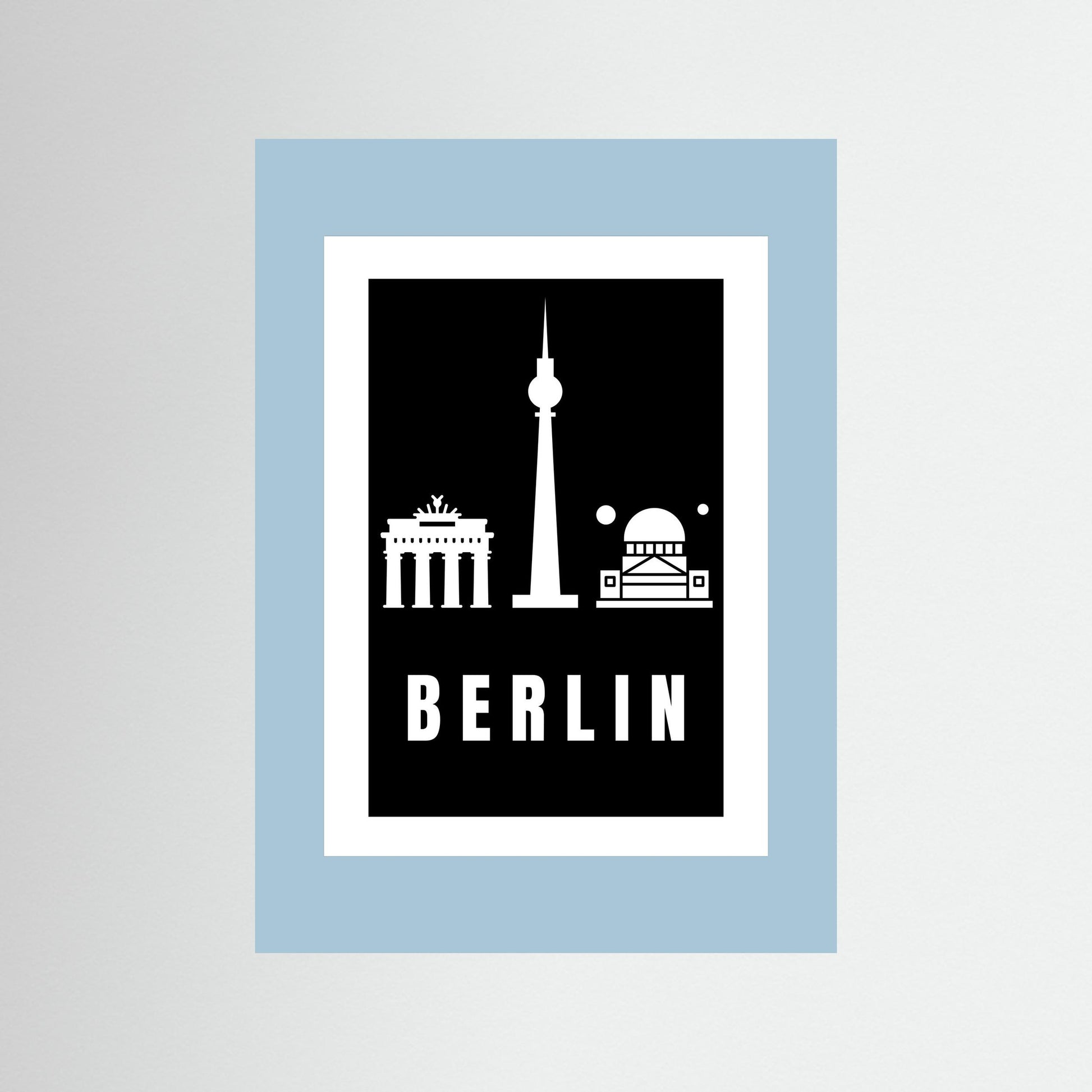 Unframed  poster with Berlin landmarks on a black background inside a light blue border.
