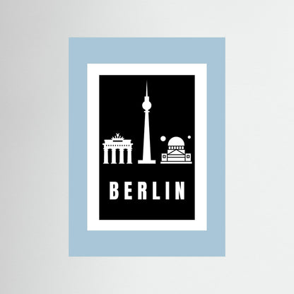 Unframed  poster with Berlin landmarks on a black background inside a light blue border.